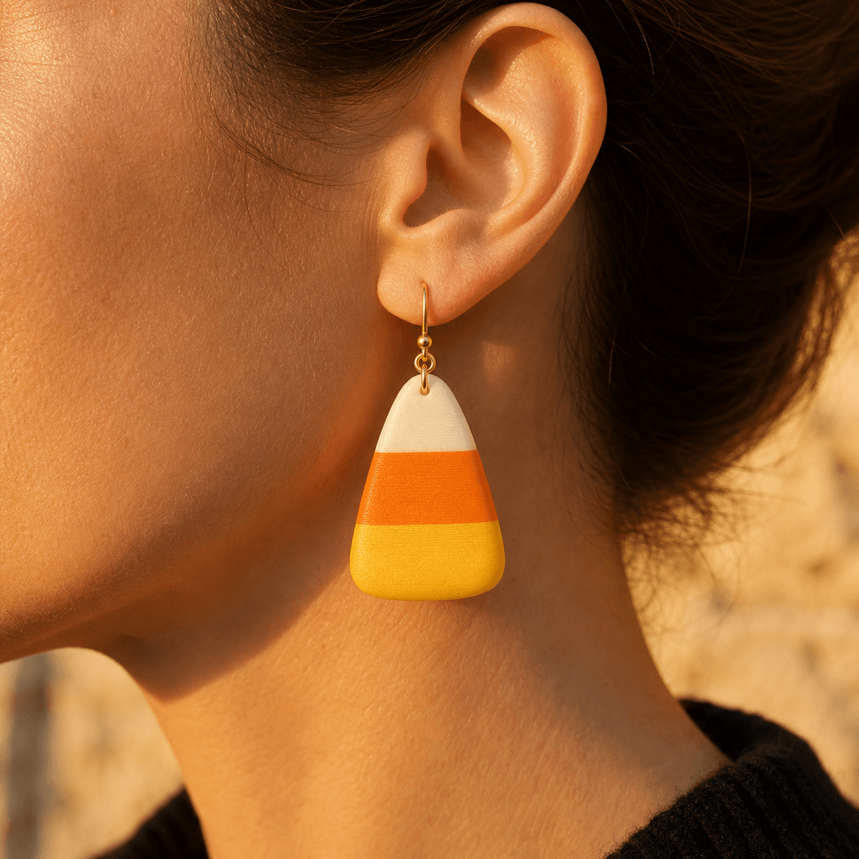 Candy Corn Earring worn, showing the roughly 1.5-inch drop in golden evening light