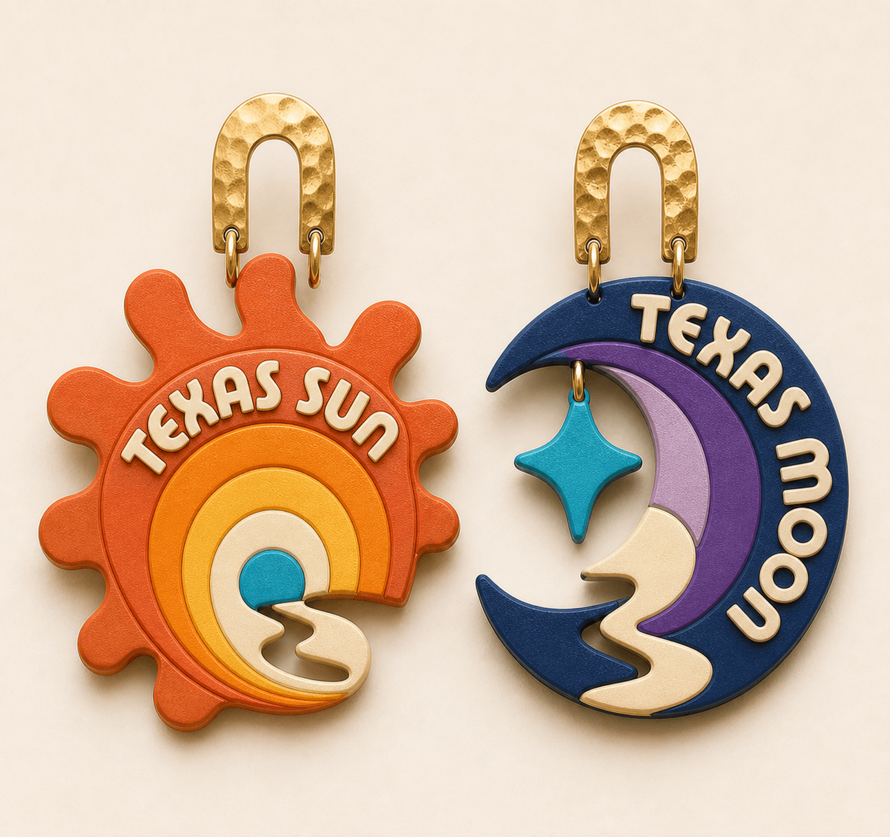 Alternate sculptural version of the Texas Sun pair — a scalloped burnt-orange sunburst with concentric arcs beside a midnight-blue crescent moon with a dangling teal star, hung from hammered gold arches